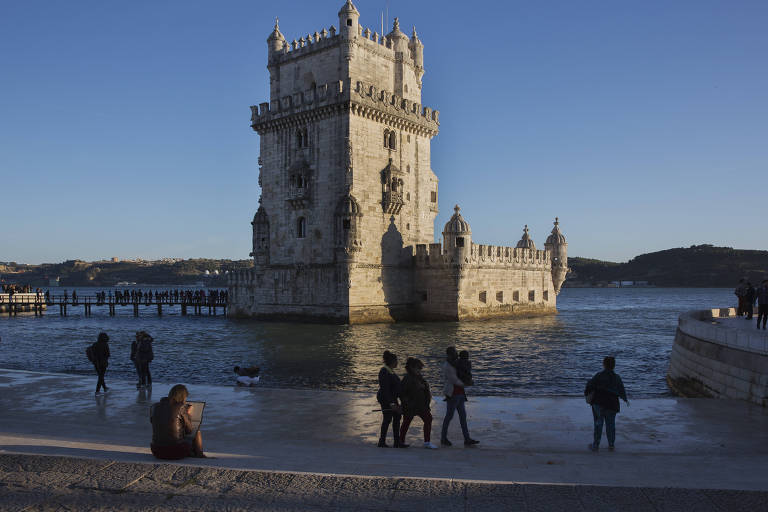 Turistas visitam a Torre de Belém, às margens do rio Tejo, em Lisboa