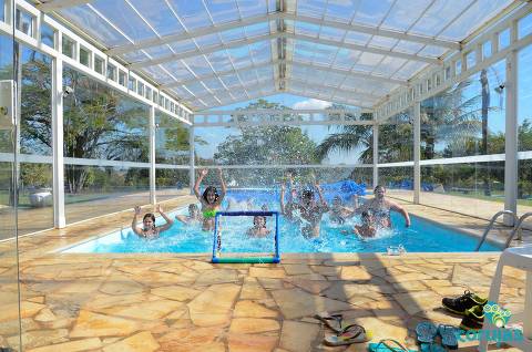 Participantes do acampamento Corujas brincam em piscina coberta 