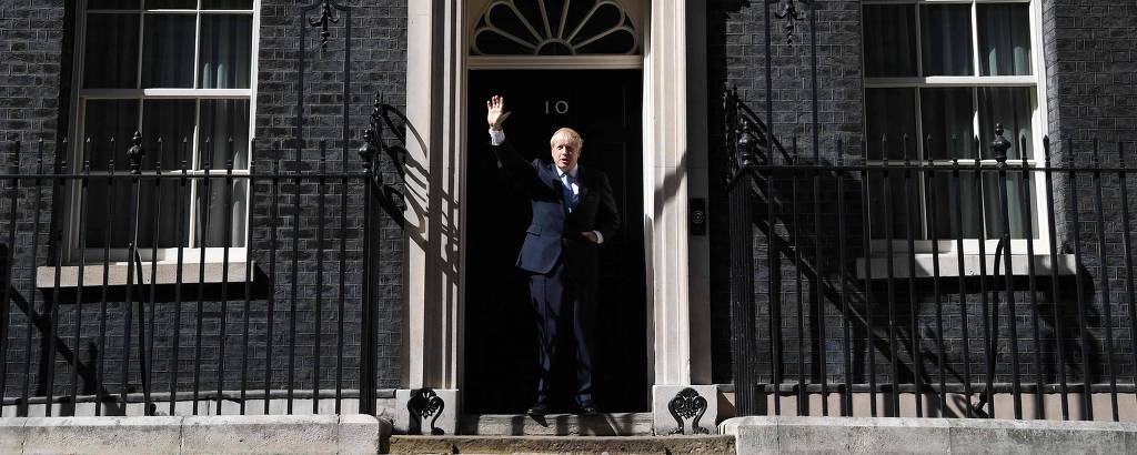 O novo premiê britânico, Boris Johnson, acena para jornalistas antes de entrar na residência oficial em Downing Street 