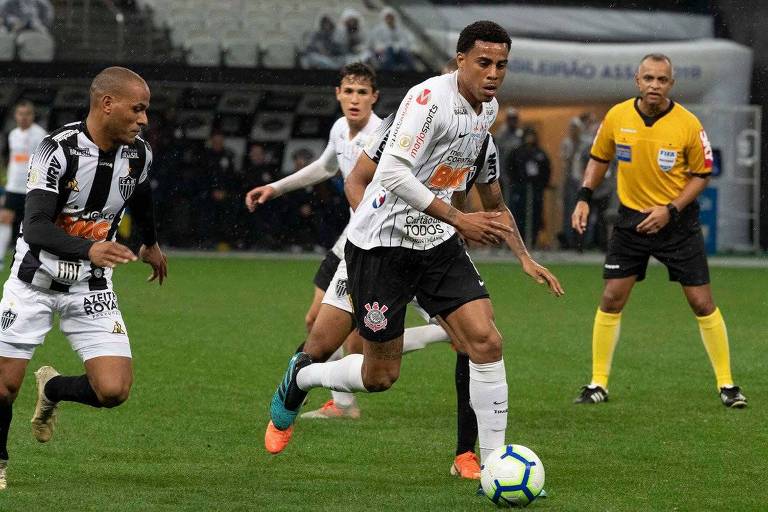 Homem de branco correndo em gramado com bola 