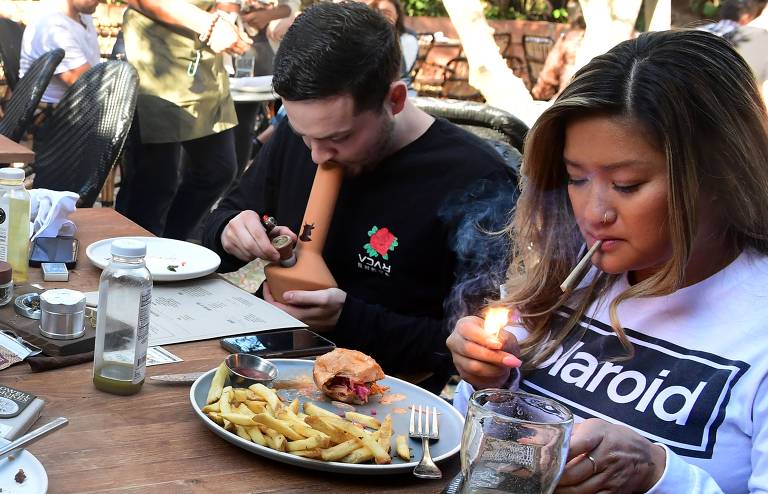 Clientes comem e fumam no Lowell Cafe, em West Hollywood, Califórnia, o primeiro restaurante temático de maconha aberto nos Estados Unidos