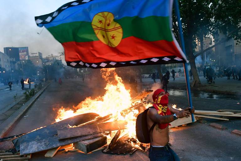 Manifestante com uma bandeira mapuche durante protesto contra o governo chileno, em Santiago