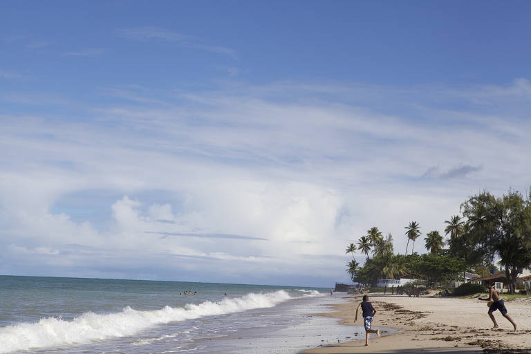 Banhistas jogam frescobol na praia do Pontal, em Pitimbu (PB)