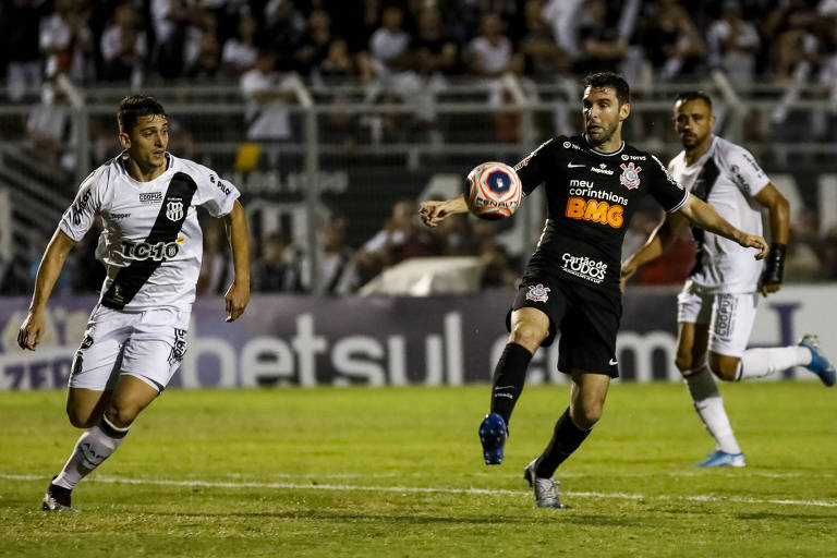 Jogadores com camisas brancas e pretas disputam em ação