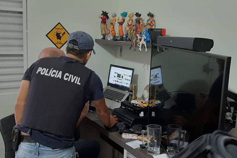 Agentes da Polícia Civil vasculham computador de suspeito na 6ª fase da operação Luz da Infância
