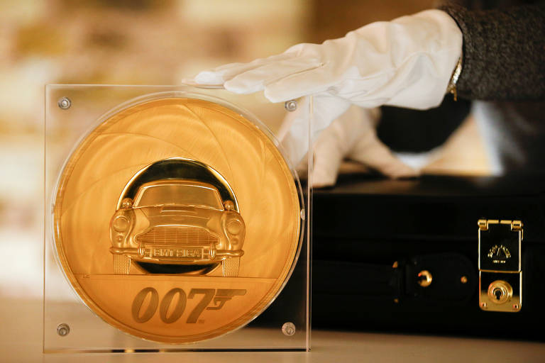 Um assistente posa com a James Bond 007 Special Issue 2020 UK Seven-Kilo Gold Proof Coin, a maior moeda já feita pelo The Royal Mint, em Londres, Grã-Bretanha