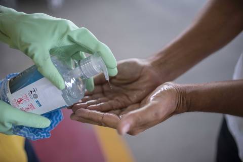 Rio de Janeiro, Rj, BRASIL. 17/03/2020;  funcionario de um supermercado aplica alcool em gel em cliente na entrada do estabelecimento  ( Foto: Ricardo Borges/Folhapress)