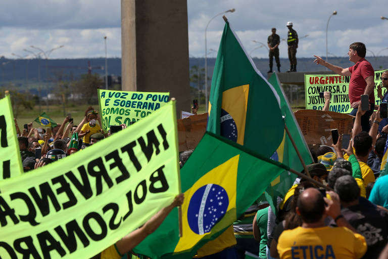 O presidente Jair Bolsonaro discursa diante do QG do Exército, em Brasília, para apoiadores que participavam de uma carreata pró-governo e contra as medidas de isolamento contra o coronavírus, neste domingo (19)