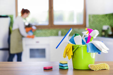 Cleaning items on wooden table in modern kitchen. Woman house work or charwoman blured in background. Bucket, brush, washcloth, spray..
Foto: Milan / Adobe stock