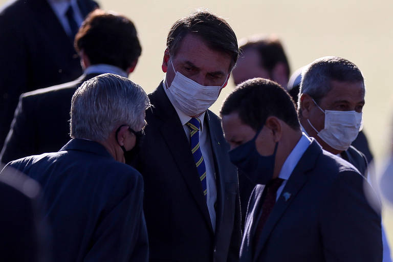 O vice-presidente Mourão (à dir.), com o presidente Bolsonaro e o ministro do Gabinete de Segurança Institucional, Augusto Heleno, durante hasteamento da bandeira no Palácio da Alvorada nesta terça (12)