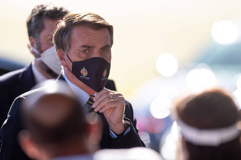 Foto mostra presidente usando máscara de proteção azul e com a mão no queixo. Seu olhar parece preocupado.