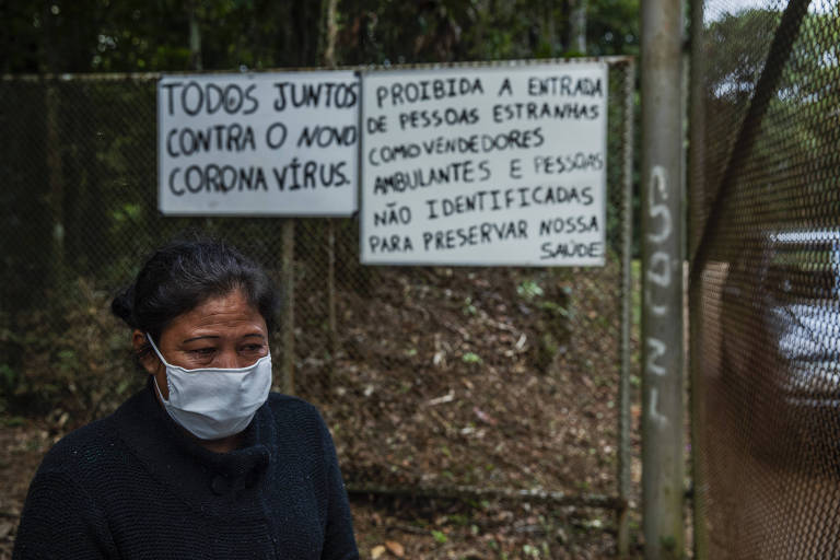 A educadora Janinha Gabriel ,42, chora em frente à entrada da aldeia, após saber que filho foi infectado