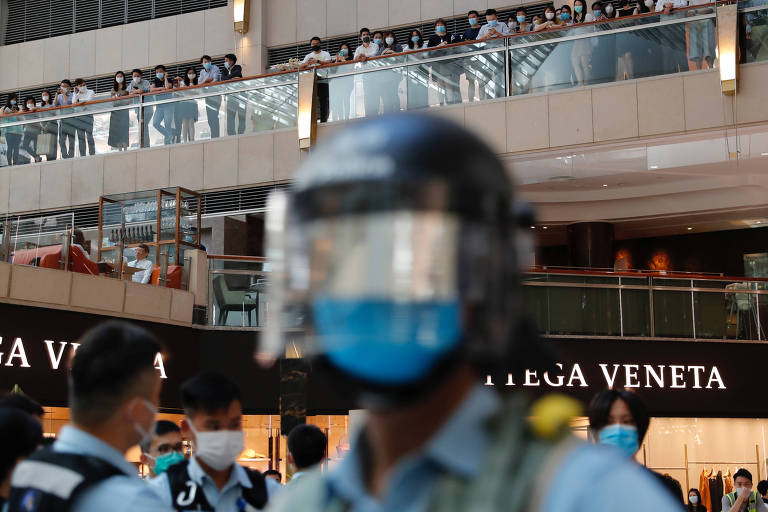 Policiais observam protesto contra a nova lei de segurança em shopping de Hong Kong
