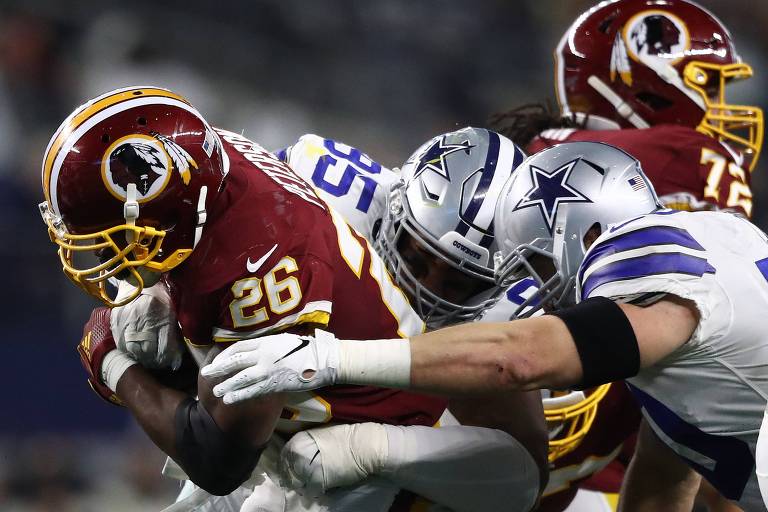 Adrian Peterson, camisa 26 do Washington Redskins, corre com a bola e fura a marcação do Dallas Cowboys