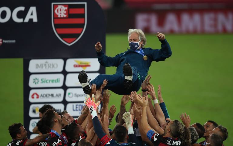 Jorge Jesus é jogado para o cima pelos jogadores do Flamengo, após a conquista do Estadual