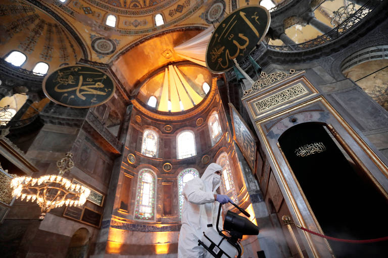 Homem faz desinfecção da Hagia Sophia, catedral que foi transformada em uma mesquita em Istambul, antes de um evento muçulmano


