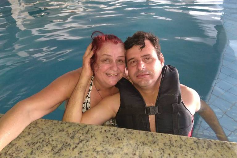 Tarcísio Duarte, 37, com a mãe, Marli, sorrindo na beirada de uma piscina