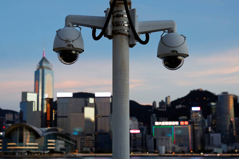 Duas câmeras no primeiro plano com os prédios de Hong Kong desfocados ao fundo