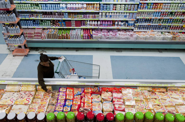 Consumidora Iracema Isabel da Silva, 43, escolhe produtos congelados no supermercado Futurama