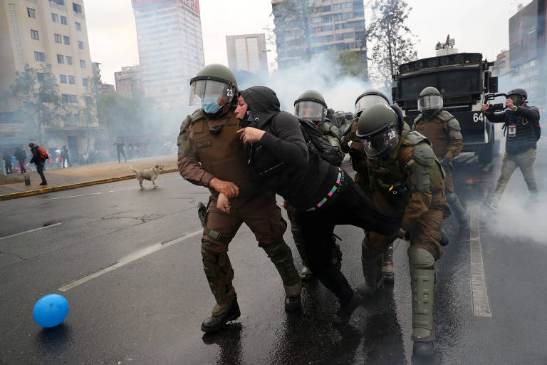 Policiais detêm manifestante durante protesto contra o governo em Santiago, no Chile