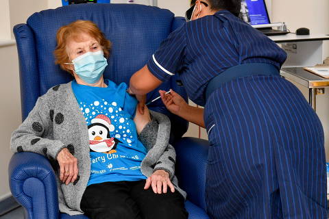 Margaret Keenan, 90, is the first patient in Britain to receive the Pfizer/BioNtech COVID-19 vaccine at University Hospital, administered by nurse May Parsons, at the start of the largest ever immunisation programme in the British history, in Coventry, Britain December 8, 2020. Britain is the first country in the world to start vaccinating people with the Pfizer/BioNTech vaccine. Jacob King/Pool via REUTERS     TPX IMAGES OF THE DAY ORG XMIT: GDN-GB