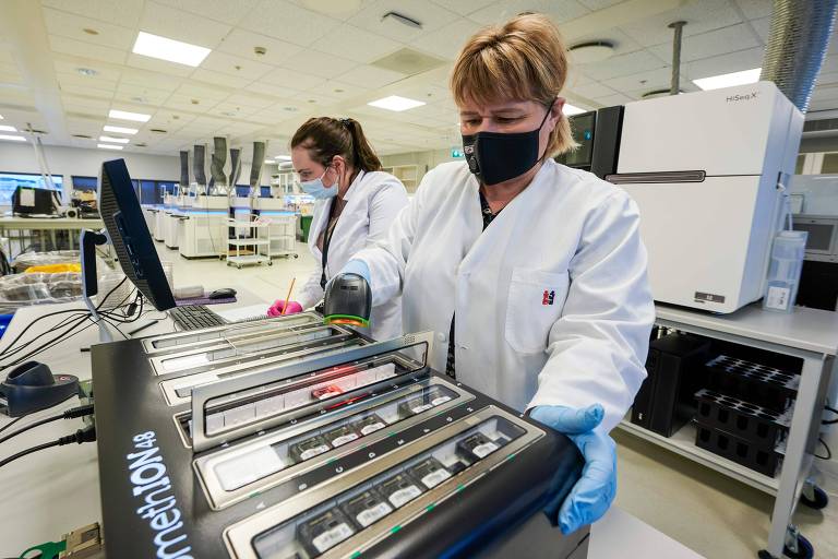 Cientistas trabalham em laboratório de Reykjavik que analisa todas as amostras coletadas de pessoas com Covid-19 para determinar a cepa e a origem do vírus