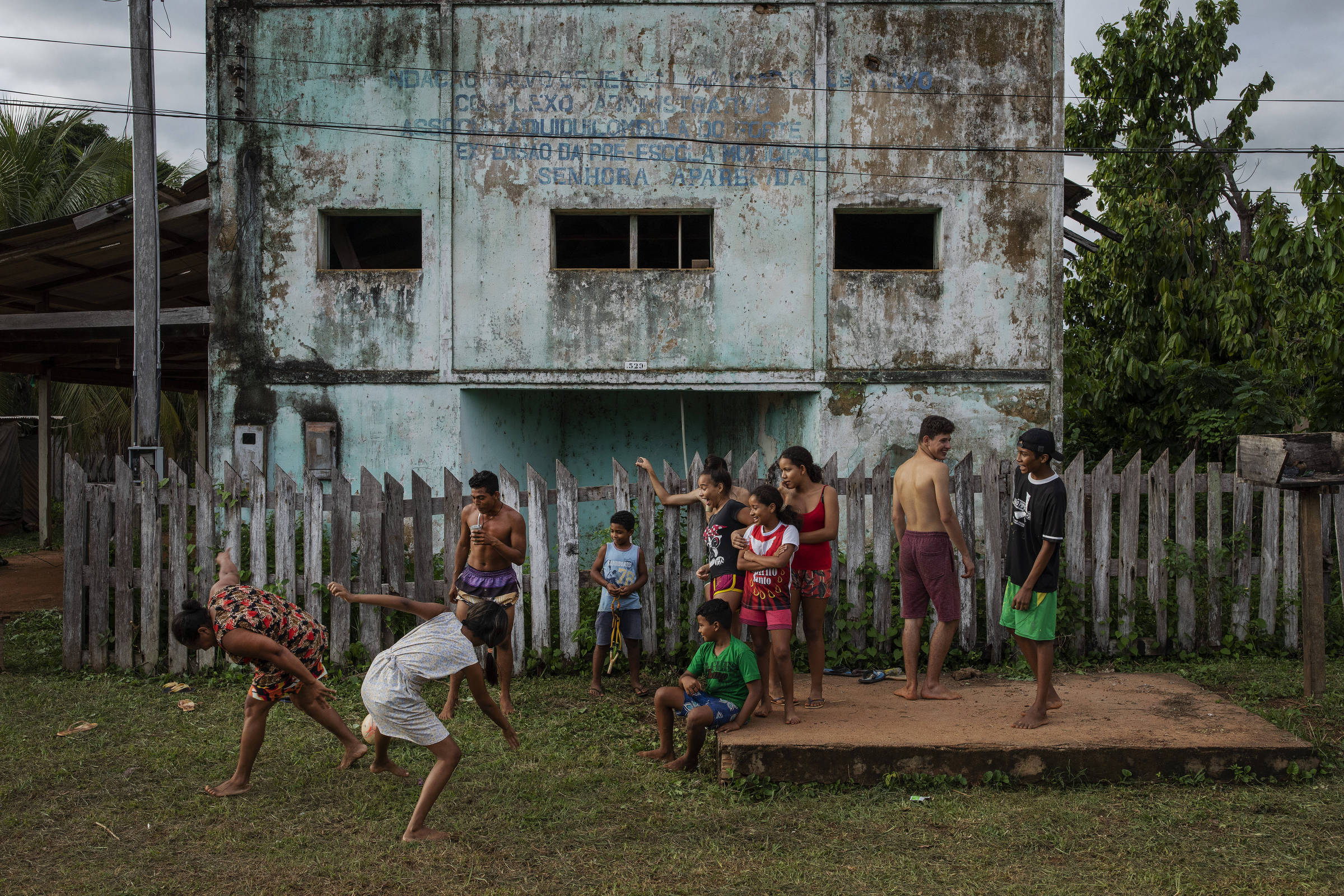 Crianças da comunidade quilombola do Forte Príncipe da Beira assistem a um jogo de futebol em frente à antiga sede da associação da comunidade