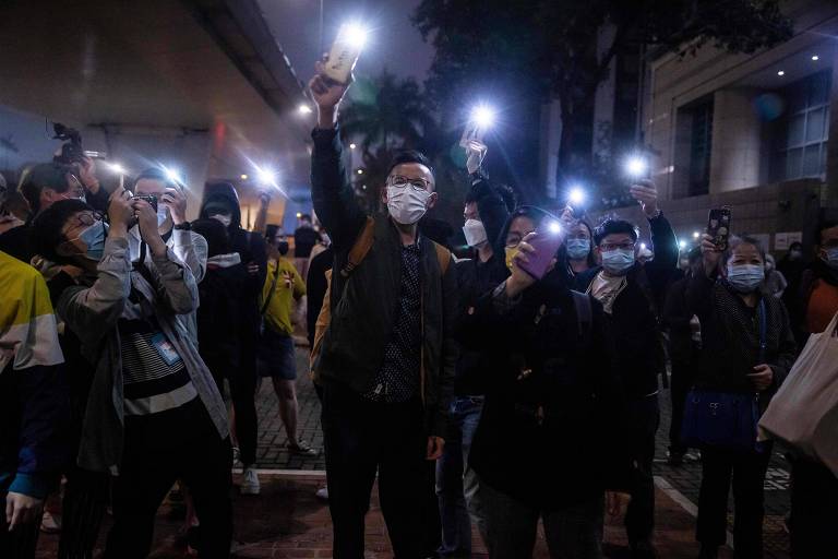 Apoiadores de ativistas pró-democracia presos em Hong Kong fazem ato em frente à corte onde ocorreu o julgamento