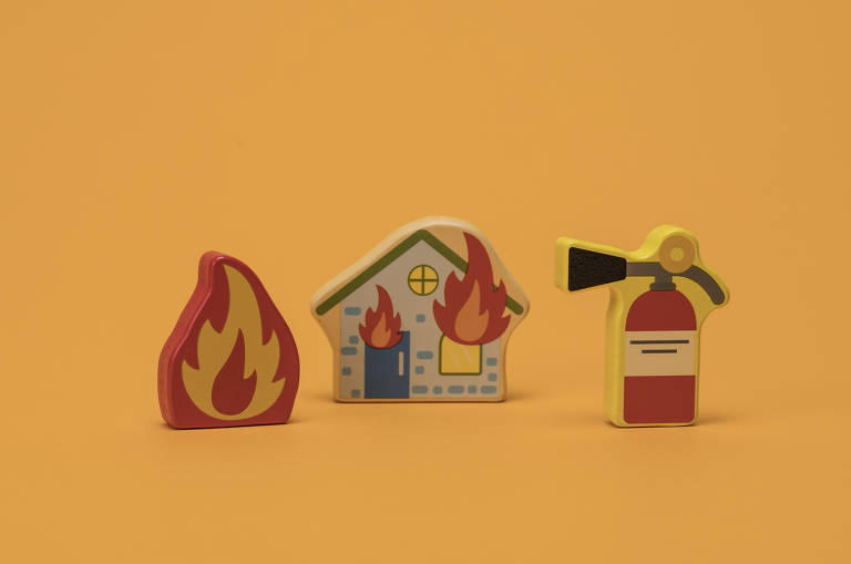 Foto mostra peças de brinquedo simulando uma chama, uma casa em chamas e um extintor