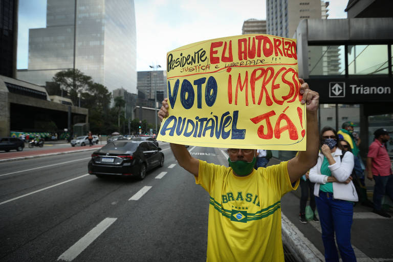 Homem com camiseta amarela do Brasil segura cartaz em que se lê "Bolsonaro eu autorizo. Voto impresso auditável já"