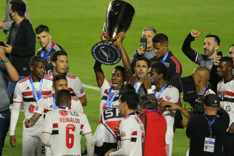 Jogadores do São Paulo celebram o título com a taça do Campeonato Paulista no gramado do Morumbi