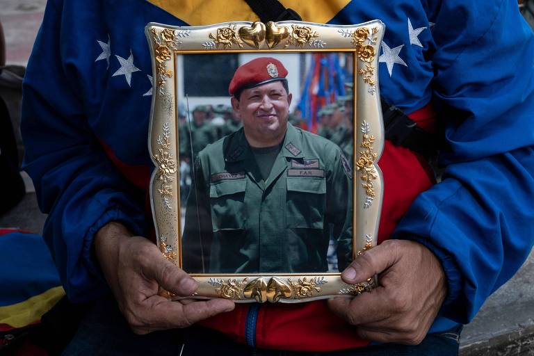 Apoiador do governo da Venezuela segura retrato de Hugo Chávez em Caracas, no oitavo aniversário da morte do líder que presidiu o país de 1999 a 2013
