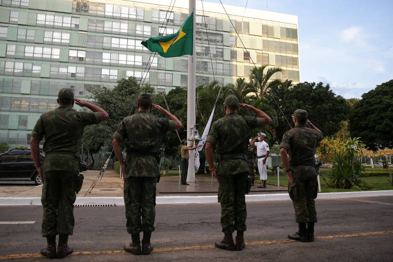 Militares fazem a cerimônia de descerramento da bandeira, em frente ao Ministério da Defesa, em Brasília (DF)