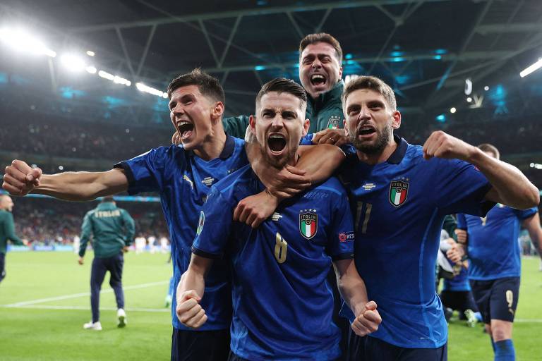 O volante brasileiro naturalizado italiano Jorginho (8) comemora com os companheiros após fazer o gol na última cobrança de pênaltis da semifinal contra a Espanha