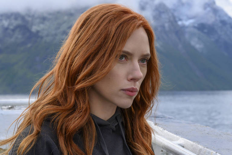 Scarlett Johansson em barco com montanhas ao fundo