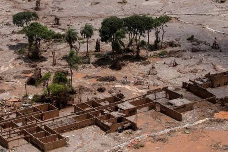 Imagem aérea mostra área rural tomada pela lama após rompimento de uma barragem