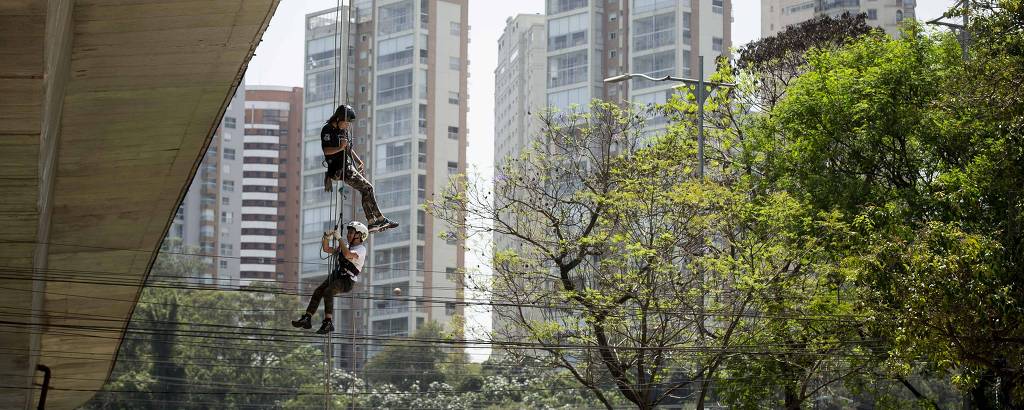 Criança e instrutor fazem rapel na Vertical Infinity, em São Paulo