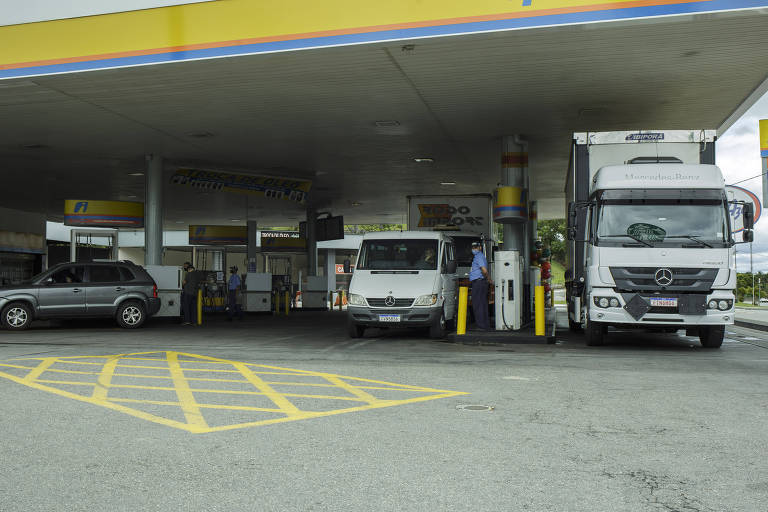 Imagem mostra posto de gasolina com carros e caminhões.