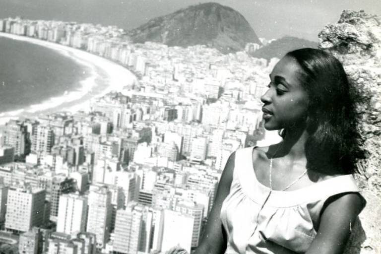 Atriz Lea Garcia posa em morro do Rio de Janeiro, com orla de praia ao fundo