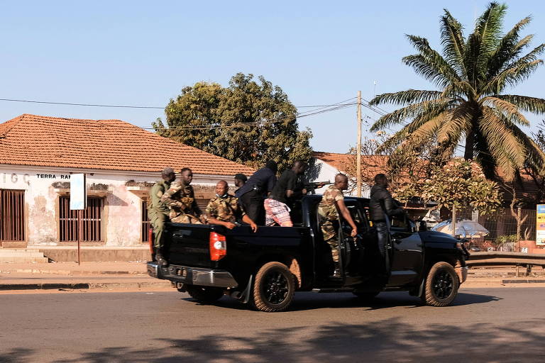 Soldados armados transitam na principal avenida da capital da Guiné-Bissau após tiroteios intensos no entorno do palácio presidencial