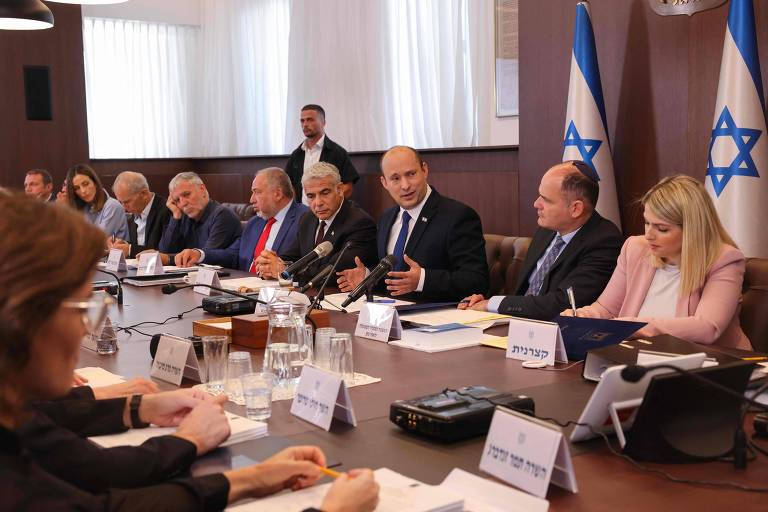Primeiro-ministro israelense, Naftali Bennett, conversa com ministros, enquanto preside a primeira reunião semanal do gabinete de seu governo, em Jerusalém