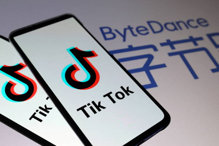 Imagem mostra celular com logo do Tik Tok. Ele está em cima de uma superfície branca com a palavra "ByteDance" escrita em azul. Embaixo, há dizeres em mandarim.