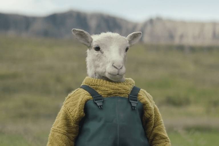 Cena do filme "Lamb", de Valdimar Jóhannsson, mostra uma ovelha vestida como uma criança humana, de suéter amarelo e jardineira jeans