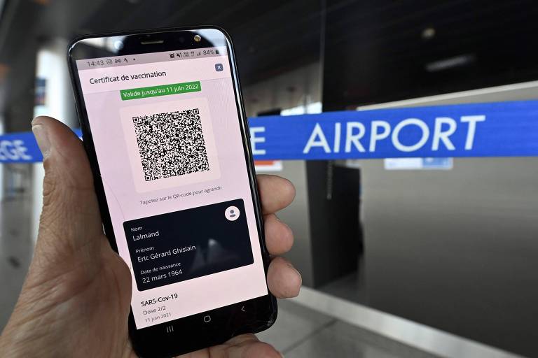 Foto tirada no aeroporto de Liège, na Bélgica, mostra a tela de um celular com o passe vacinal europeu
