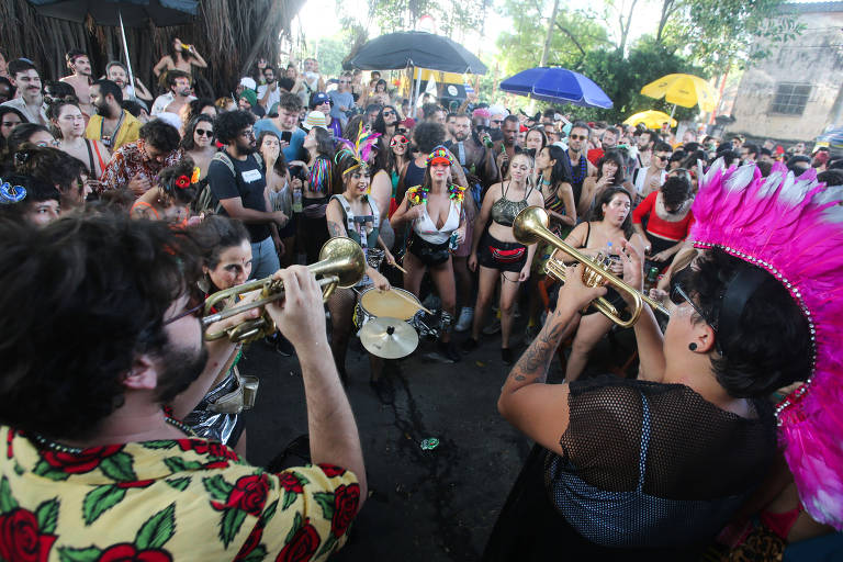 Foliões dançam em volta de músicos