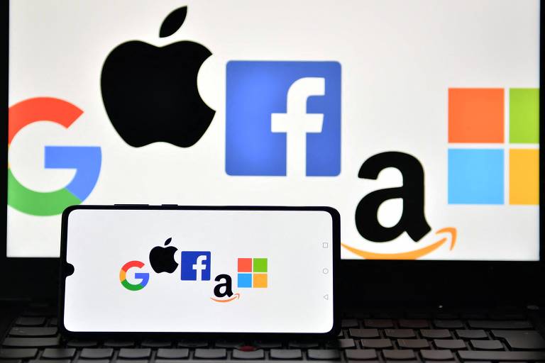 Logos de Google, Apple, Facebook, Amazon e Microsoft em foto ilustrativa. À frente, está um celular.