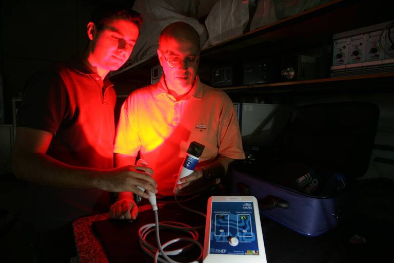 O professor Vanderlei Salvador Bagnato (à dir.), do Instituto de Física da USP de São Carlos, e o colaborador Mardoqueu Martins da Costa manipulam o kit de equipamento para o tratamento de câncer de pele, projeto de terapia por fotodinâmica desenvolvido pela equipe do professor