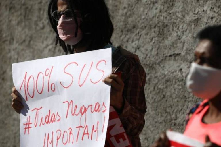 Manifestante segura cartaz em apoio ao SUS e a vidas negras