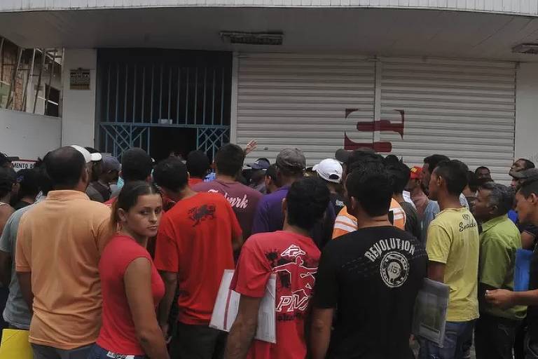 Aglomerado de pessoas em frente a um comércio