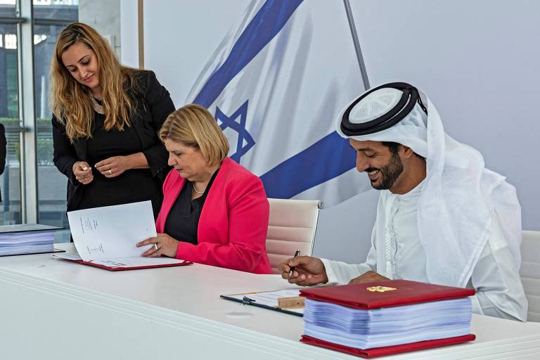 Os ministros da Economia de Israel, Orna Barbivai (meio) e dos Emirados Árabes Unidos, Abdulla bin Touq al-Marri (à dir.), durante assinatura de acordo entre os dois países